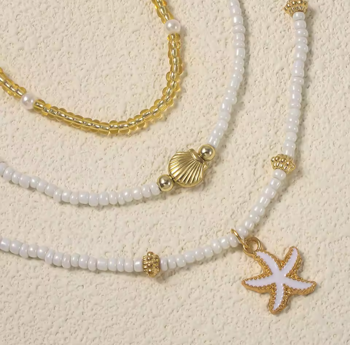 SET 3 PEZZI COLLANA CON PERLE DI RISO, STELLE MARINE E CONCHIGLIE DORATE