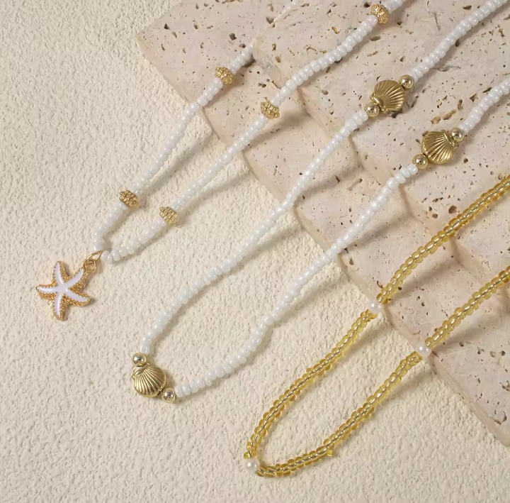 SET 3 PEZZI COLLANA CON PERLE DI RISO, STELLE MARINE E CONCHIGLIE DORATE